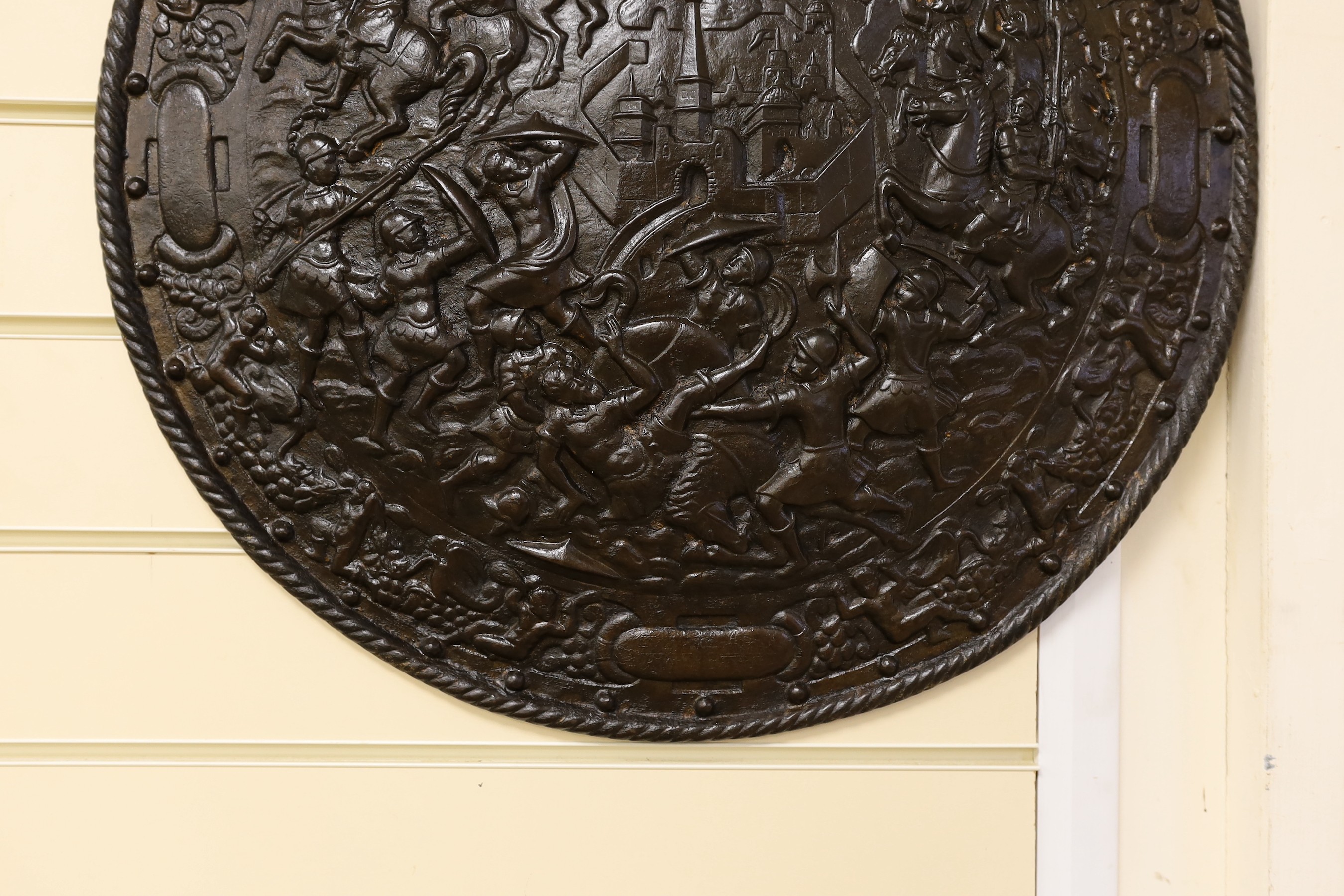 A Victorian cast iron shield shaped wall plaque, 55cms diameter.